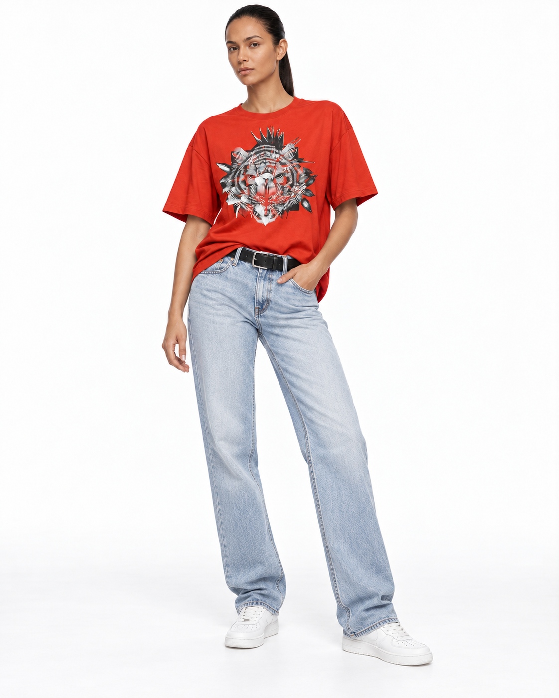 Model wearing a red graphic T-shirt and light blue jeans, pose 1