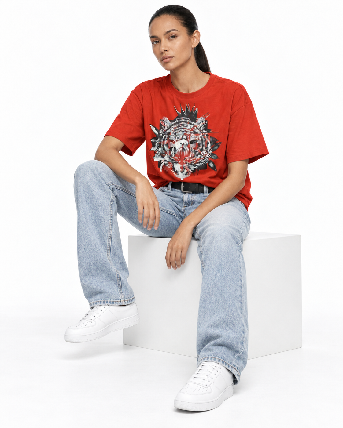 Model wearing a red graphic T-shirt and light blue jeans, pose 2